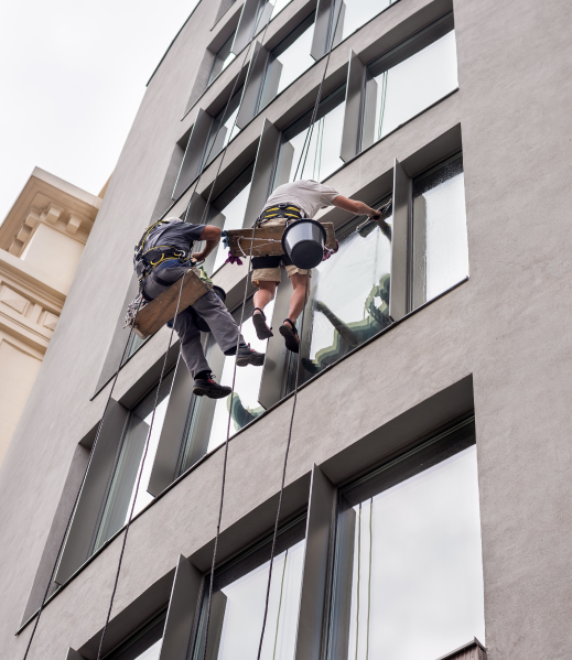 Rope access technicians cleaning the windows of an office building
